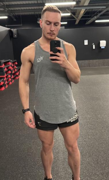 A man in a gym taking a selfie.