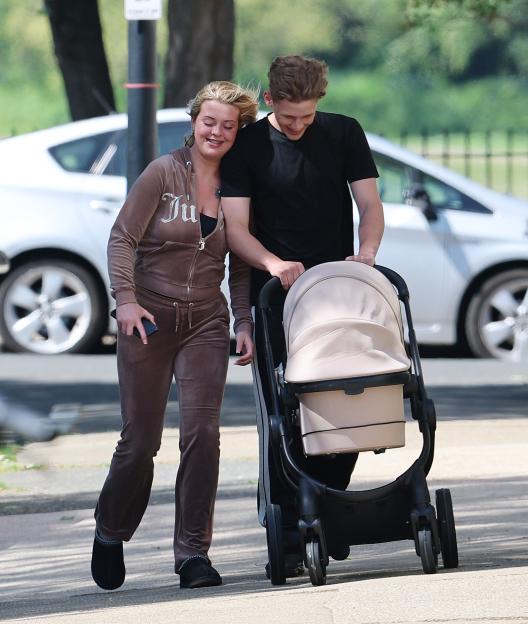 Freddy Brazier and Holly Swinburn with their baby Isla in a pram.
