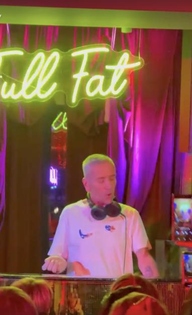 DJ Fat Tony at a DJ booth with a "Full Fat" neon sign.