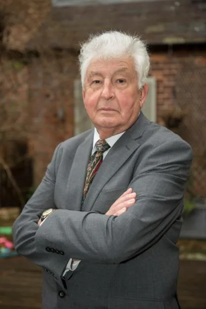 Former Police Detective Stuart Clifton, dressed in a grey suit, with his arms crossed.