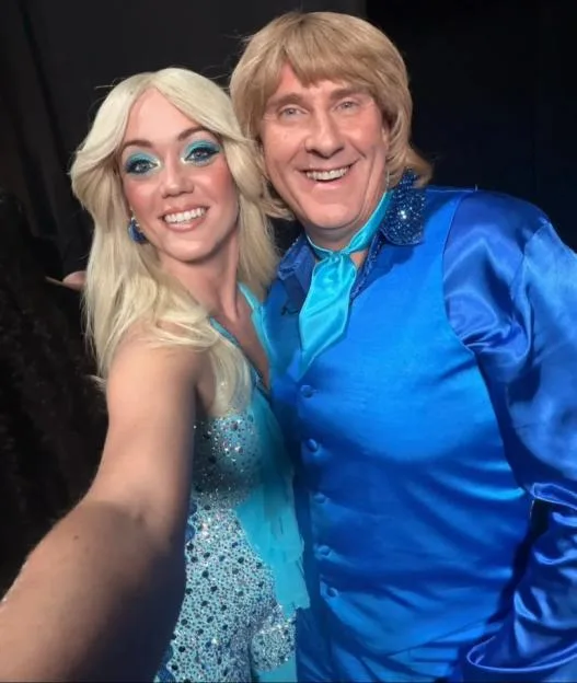 Lauren Oakley and Graeme Hall dressed in 1970s ABBA-style blue outfits.