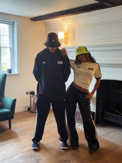 Karen Hauer and her boyfriend posing in matching Adidas outfits and bucket hats.