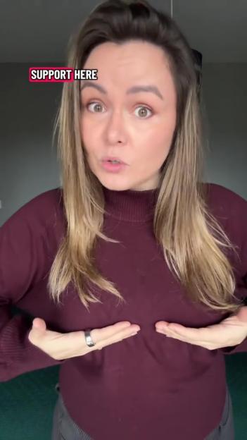 A woman in a burgundy top points to her chest with her hands, with text on the screen that says "SUPPORT HERE".