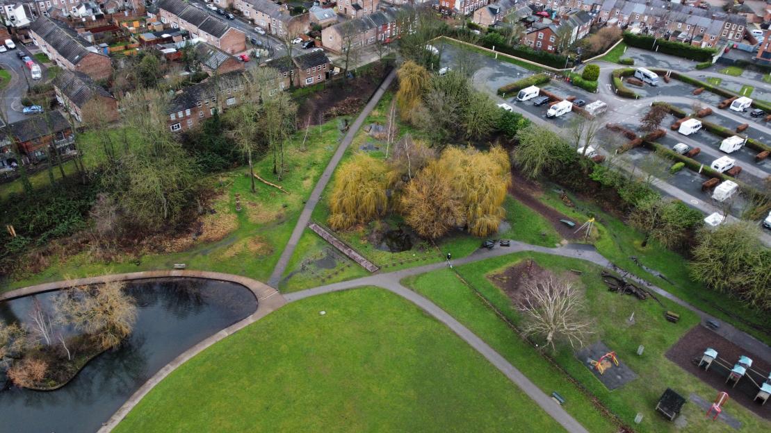 An aerial view of Rowntree Park in York with a small puddle fenced off near a boardwalk.