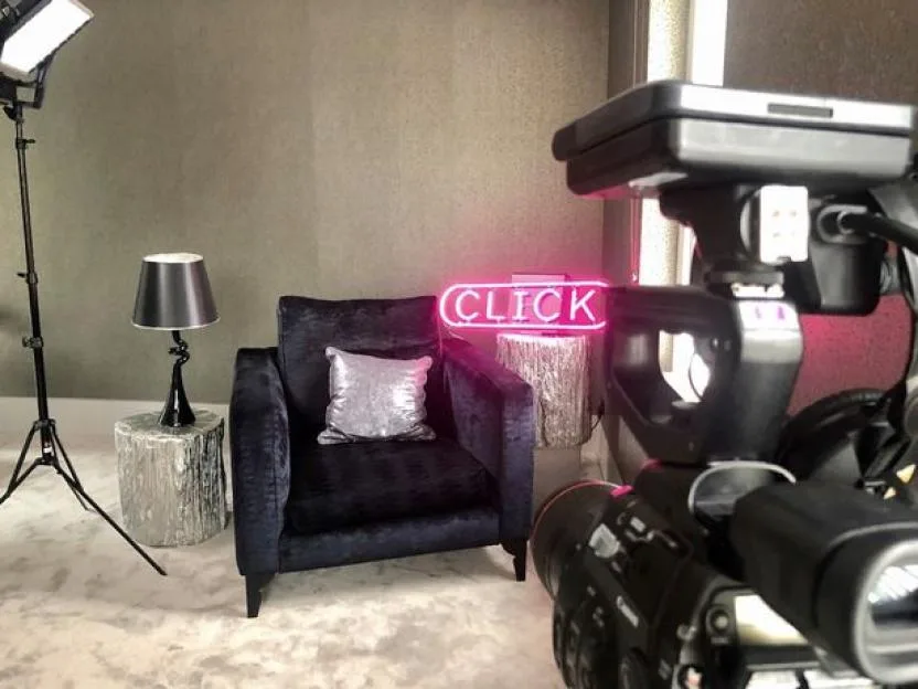 Filming setup for BBC Click, including a camera, lighting, and a set with a chair and neon "CLICK" sign.