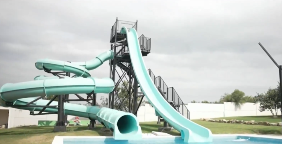 Water park with teal slides entering a pool.