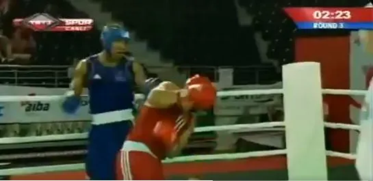 Two boxers in a ring; one in red, one in blue.