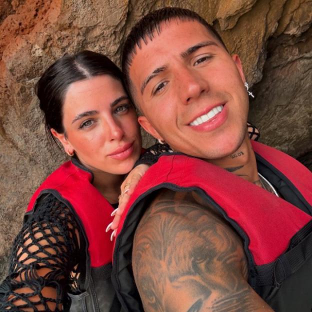 A man and a woman in red life vests, posing for a selfie.