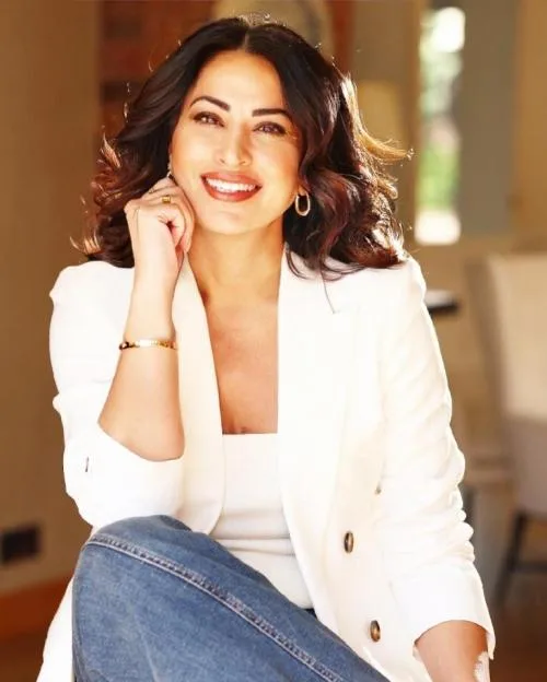 Jinda Mann smiling and wearing a white blazer.
