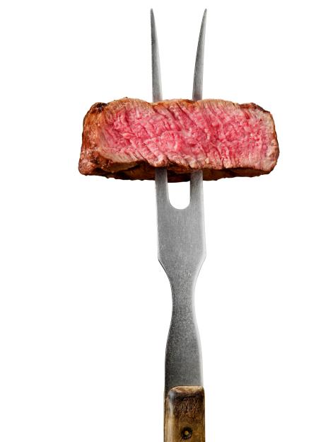 Medium rare sirloin steak on a carving fork.