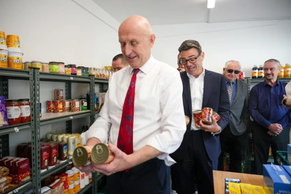 John Healey and Andy Burnham help stock shelves at The Independence Initiative charity in Liverpool.