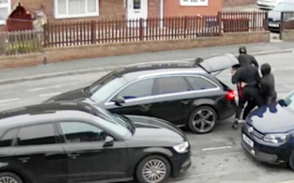 CCTV footage shows three masked men forcing a victim into the open boot of a black Audi A4.