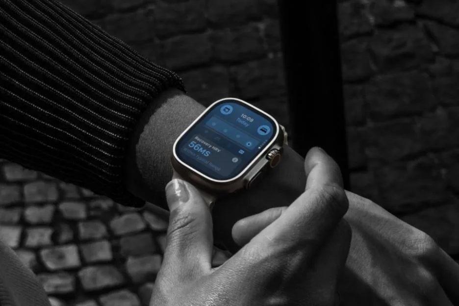 Close-up of a person wearing an Apple Watch Ultra displaying recovery metrics.