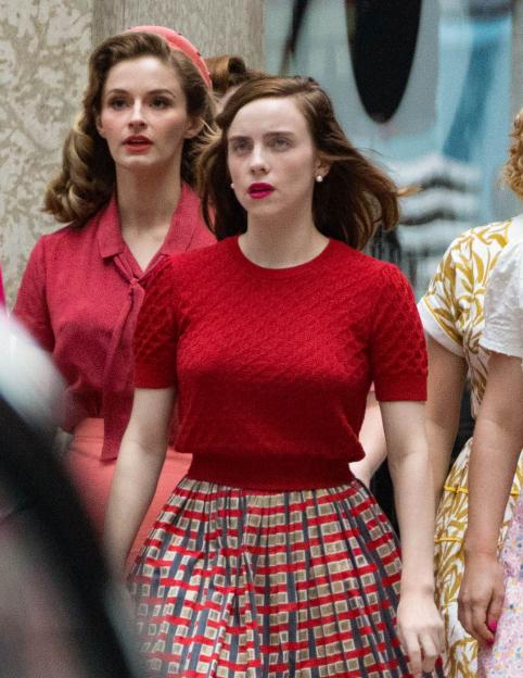 Billie Eilish on set for the film "The Bell Jar" in a red textured top and plaid skirt.