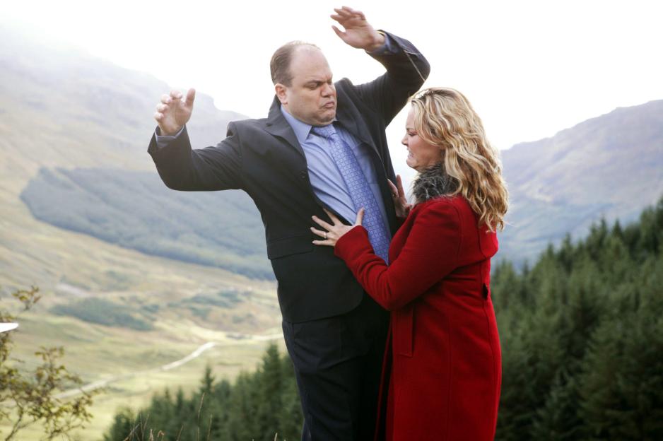 Actors Charlie Brooks as Janine Butcher and Shaun Williamson as Barry Evans in an outdoor scene from EastEnders.
