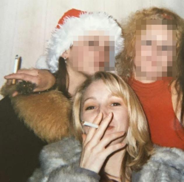 Three women posing for a picture at a Christmas party, two of whom are smoking cigarettes.