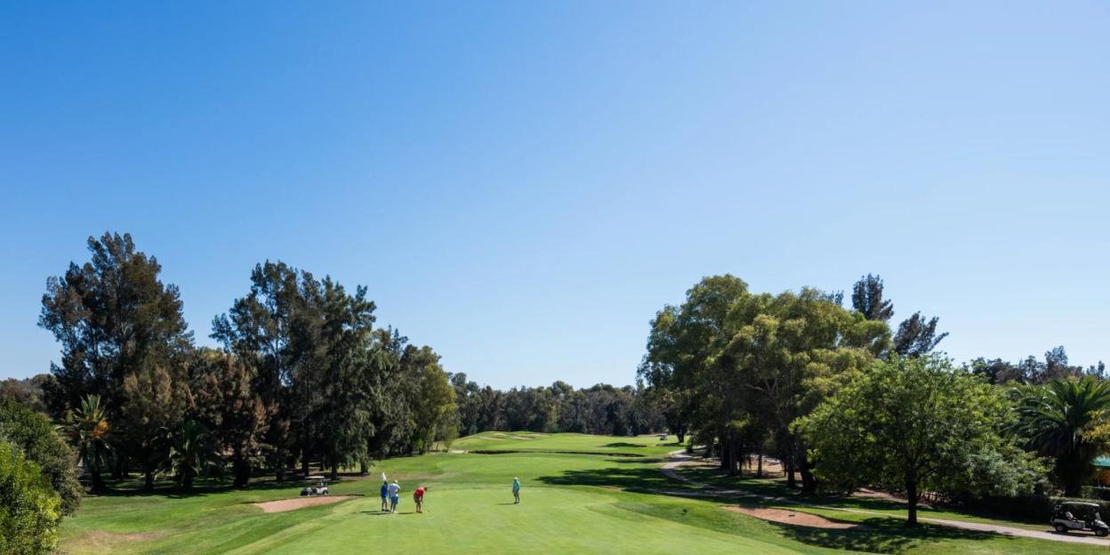 Penina Golf Resort with golfers on the green and golf carts nearby.