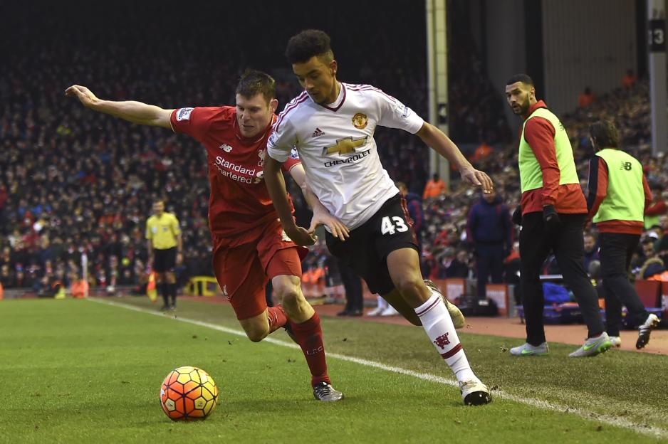 Manchester United's Cameron Borthwick-Jackson dribbles past Liverpool's James Milner during a football match.