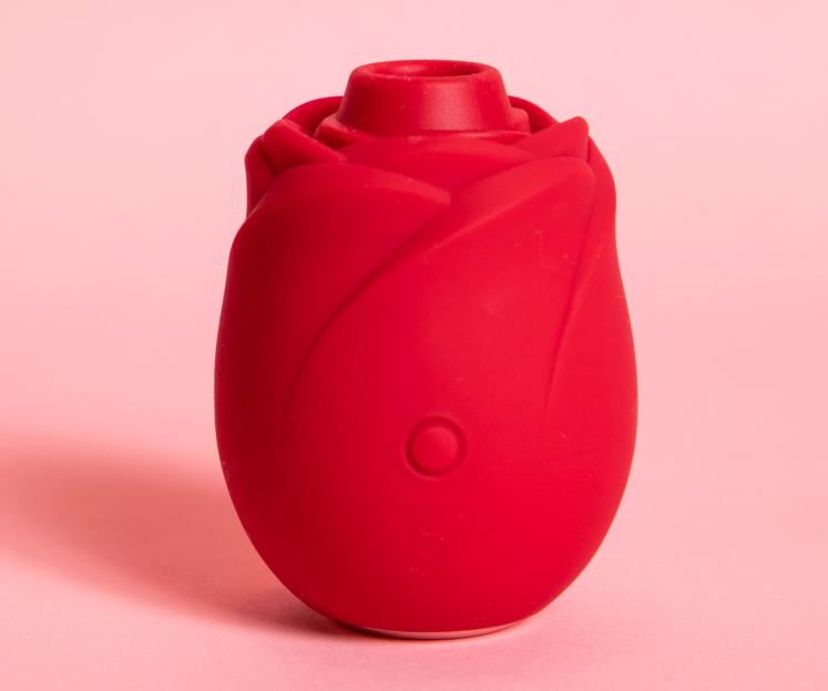 Red rose-shaped vibrator on a pink background.
