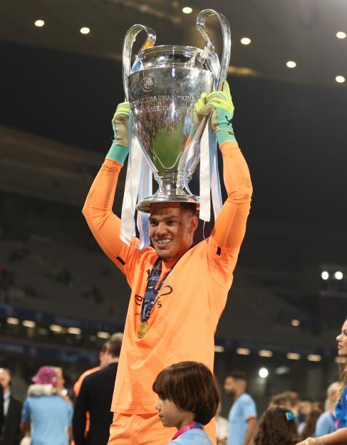 Ederson Moraes holding the UEFA Champions League trophy.