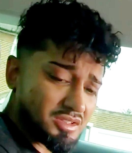 Imran Uddin, with dark curly hair and a beard, looks down with a grimace.