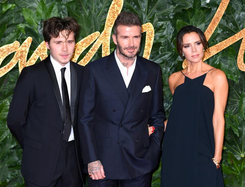 Brooklyn, David, and Victoria Beckham pose together.