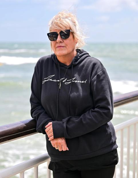 Alison Jacobson leaning on a railing overlooking the ocean.