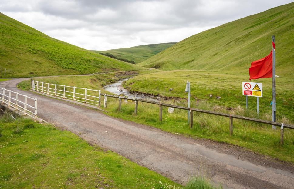 A red flag and danger sign in the Otterburn military range of Northumberland National Park.