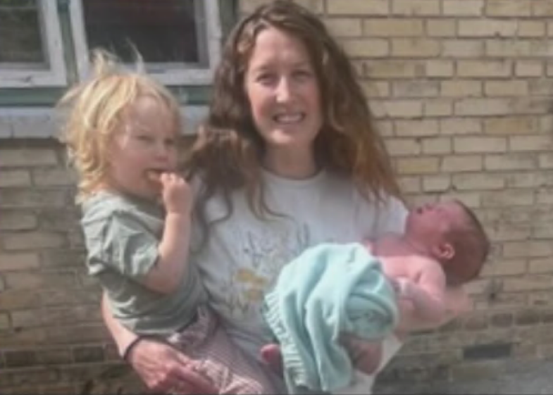 A woman holding a toddler and a newborn baby.
