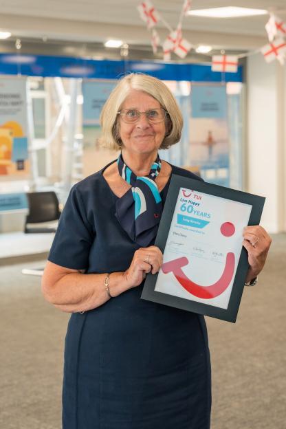 Ellen Davey, Britain's oldest travel agent, holding a framed certificate for 60 years of long service from TUI.