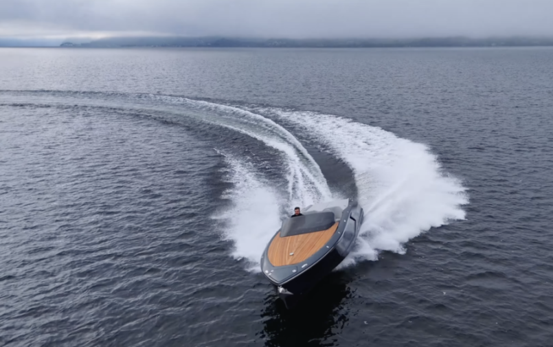 A man driving a speedboat, turning sharply, leaving a large white wake in its path.