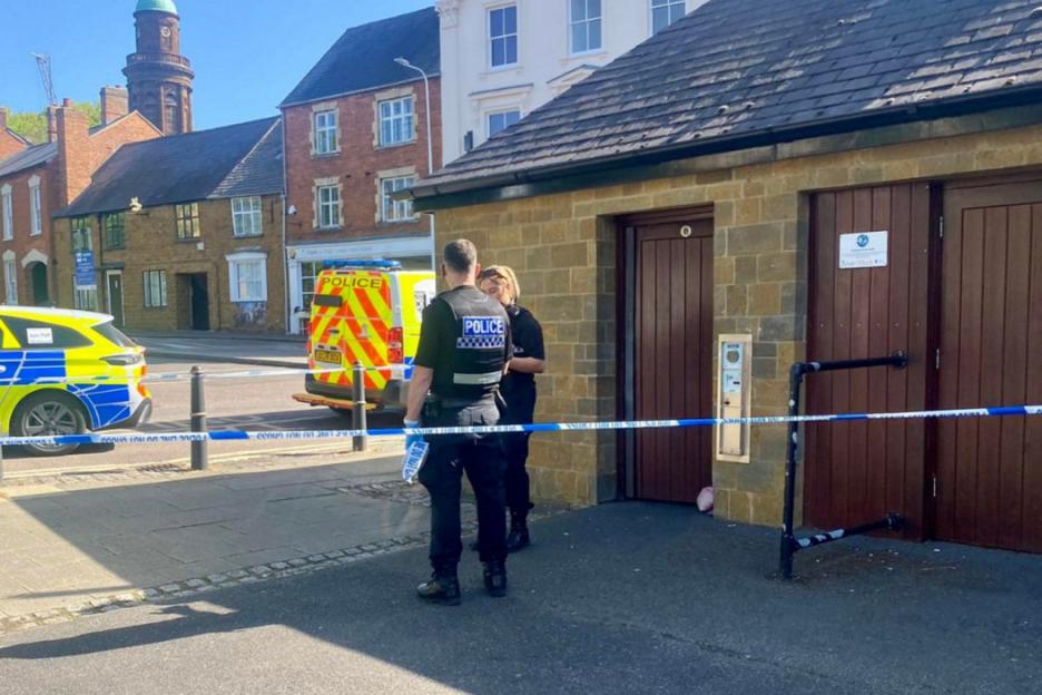 Police at a cordoned-off public toilet where a woman's body was found.