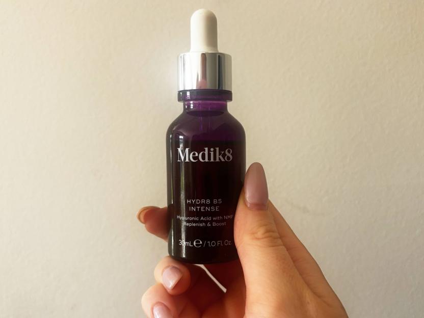 Hand holding a Medik8 HYDR8 B5 INTENSE hyaluronic acid serum bottle.