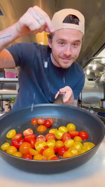 Brooklyn Beckham adding water to a pan of tomatoes.