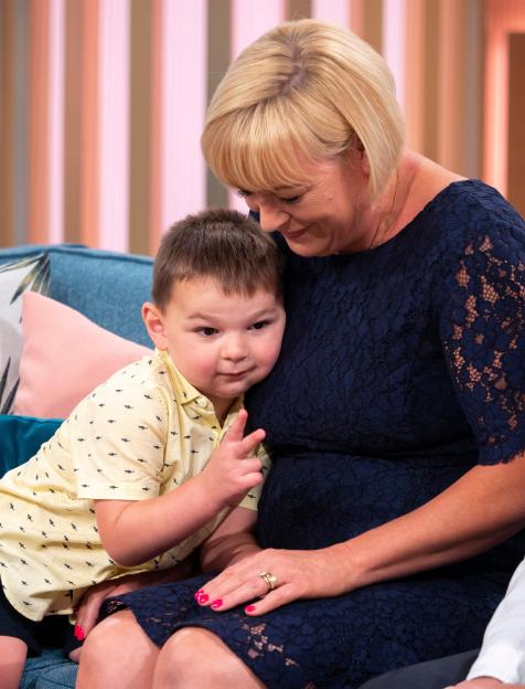 Paula Hudgell embracing her adopted son, Tony Smith, who is making a peace sign with his fingers.