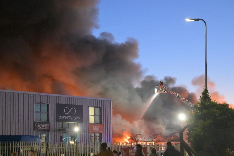 Massive Fire Breaks Out at Car Dealership: Authorities Urge Public to Stay Clear as Smoke Fills the Sky