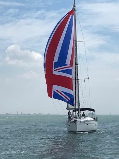 The Bright Future yacht with a sail depicting the Union Jack, seen from the front.