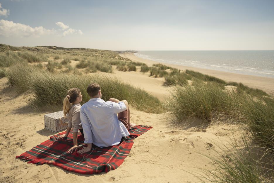 Couple enjoying a beach picnic.