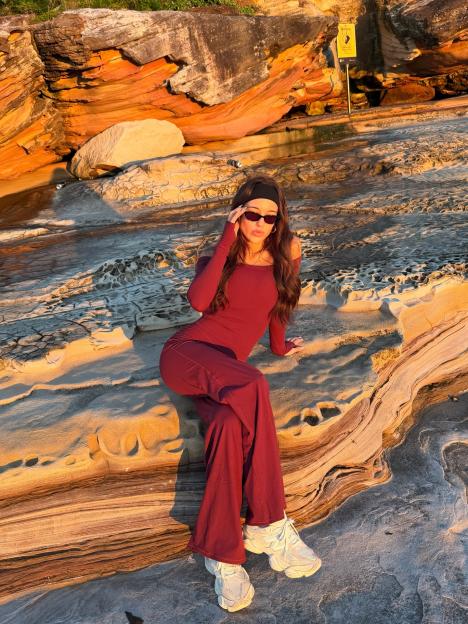 Love Island Australia star Yana Marks seated on rocks.