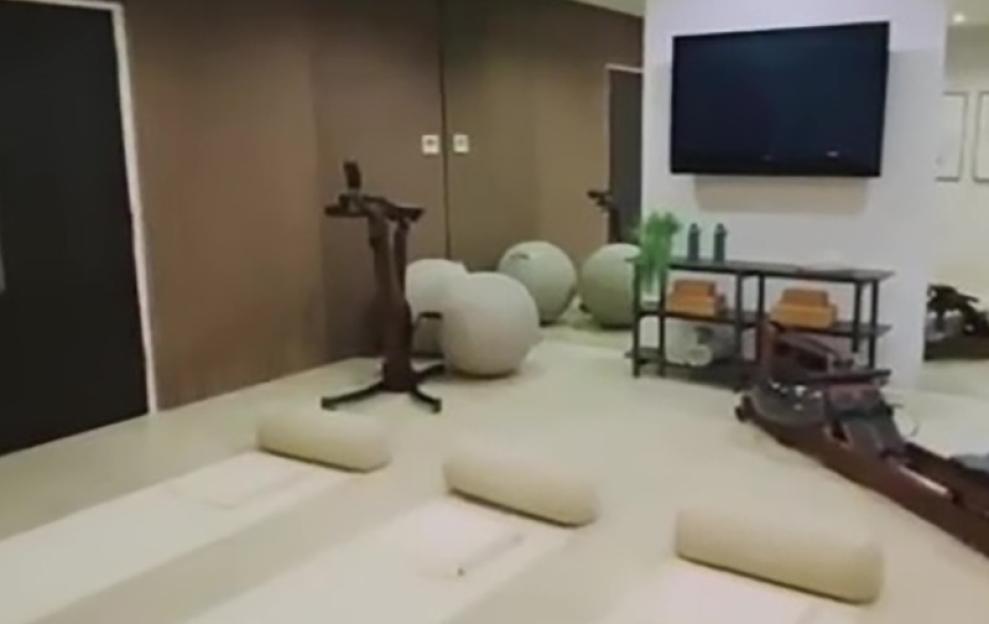 A home gym with yoga mats, exercise balls, and a rowing machine.