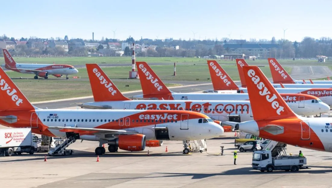 Several EasyJet airplanes parked at an airport.