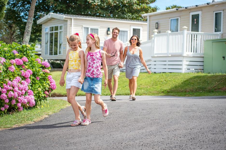 A family of four walking on a paved road at South Bay Holiday Park in Devon.