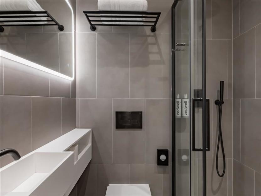 Modern bathroom featuring a shower, toilet, and sink.