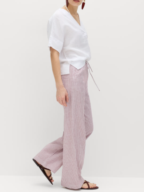 Model wearing white blouse and M&S striped trousers.