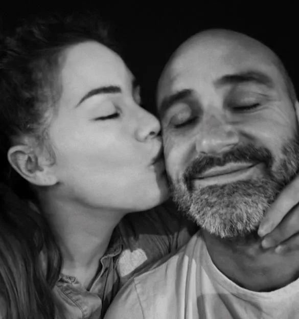 Roxanne McKee kisses her boyfriend on the cheek in a black and white photo.