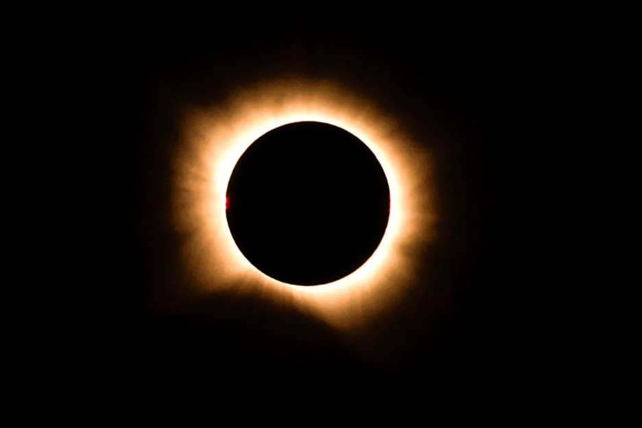 Total solar eclipse showing the sun's corona and a prominence.