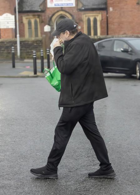 Peter Kay eating a bacon roll from a bakery.