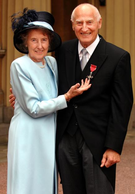 John Barrett, former 'voice of Wimbledon', with wife Angela Mortimer, the 1961 Wimbledon tennis ladies singles champion, after he collected his MBE from the Prince of Wales at an Investiture ceremony at Buckingham Palace today.