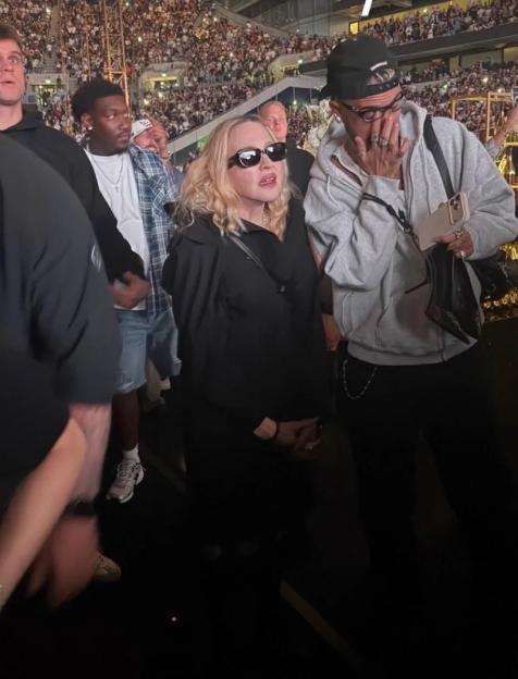 Madonna in sunglasses with a crowd behind her.