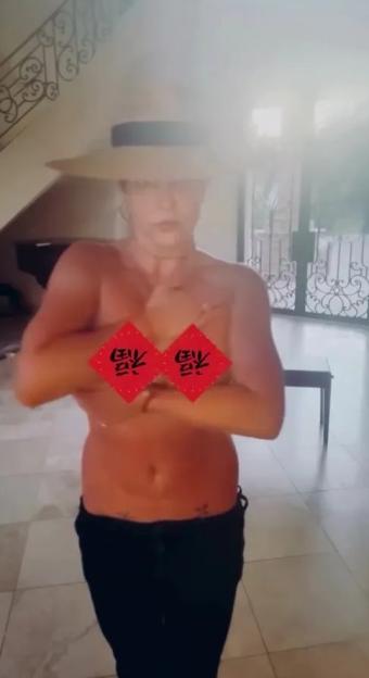Britney Spears topless in a hat, dancing.
